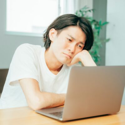 パソコンの前で悩む男性