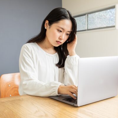 パソコン前で悩む女性